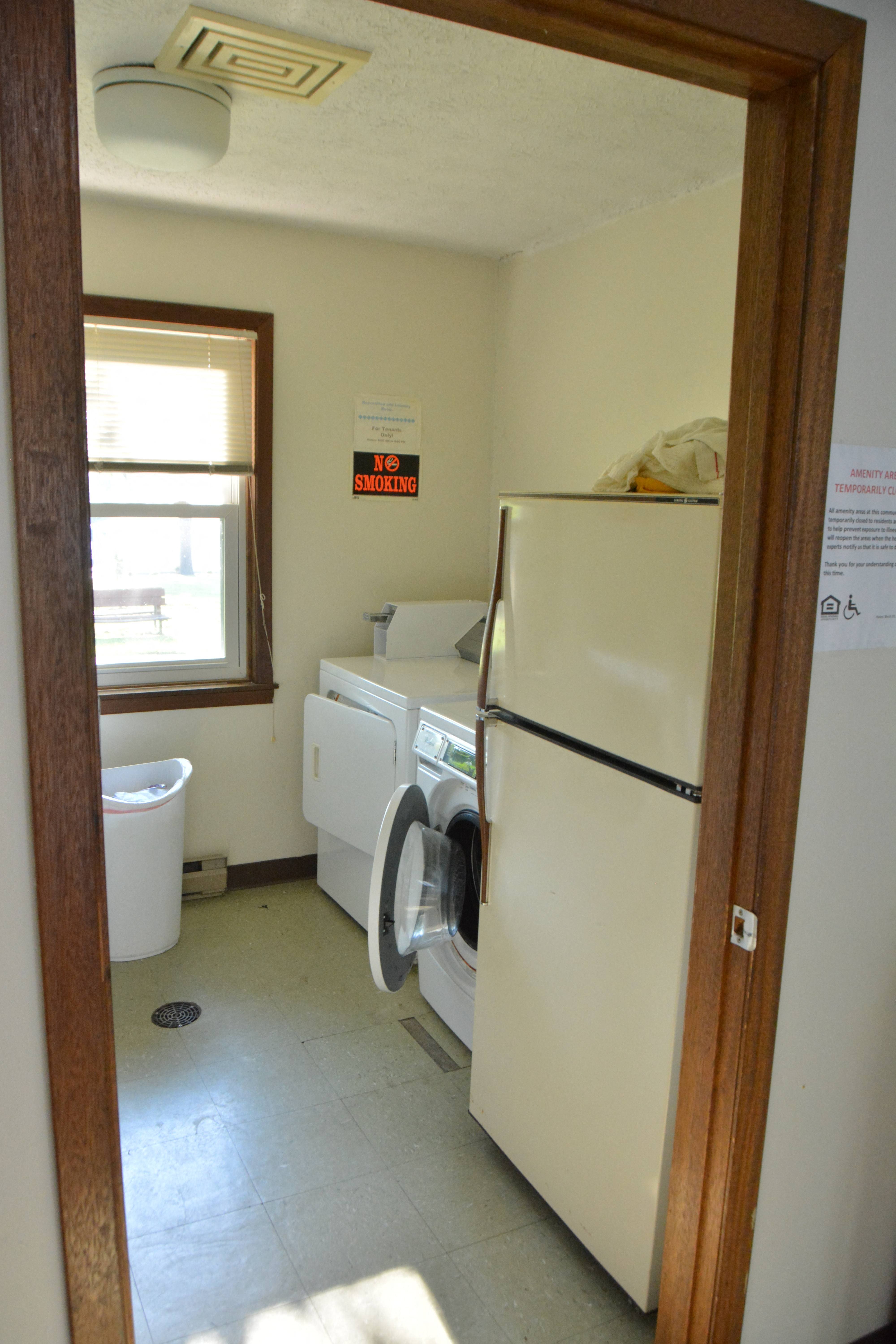 a laundry room with a refrigerator and a washing machine